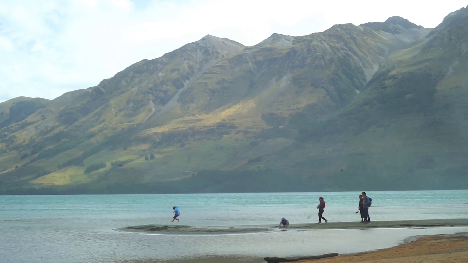 A family spending time beside a mountain lake