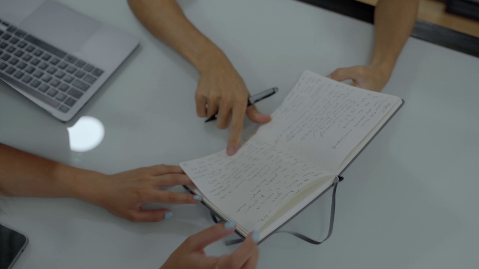 Two people reviewing notes together at a desk